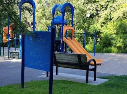 Blue and yellow playground structure with a park bench in Yongehurst, Richmond Hill, Ontario